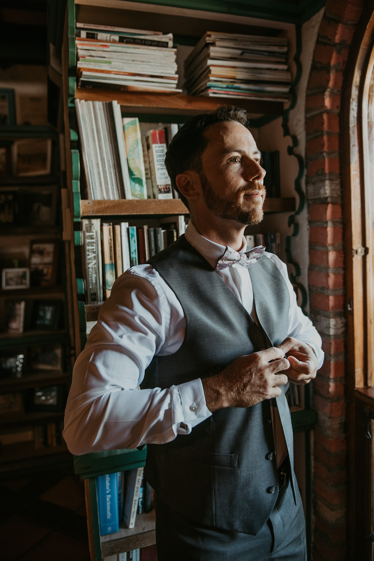 Groom getting ready at the library of Hacienda Siesta Alegre in Rio Grande.