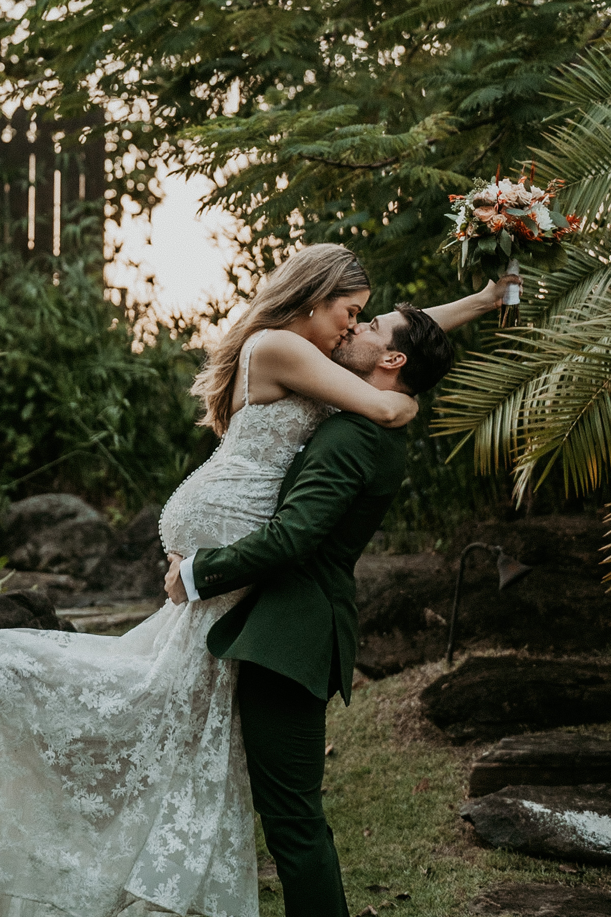 Groom carrying bride for a candid photo at Hacienda Siesta Alegre wedding.