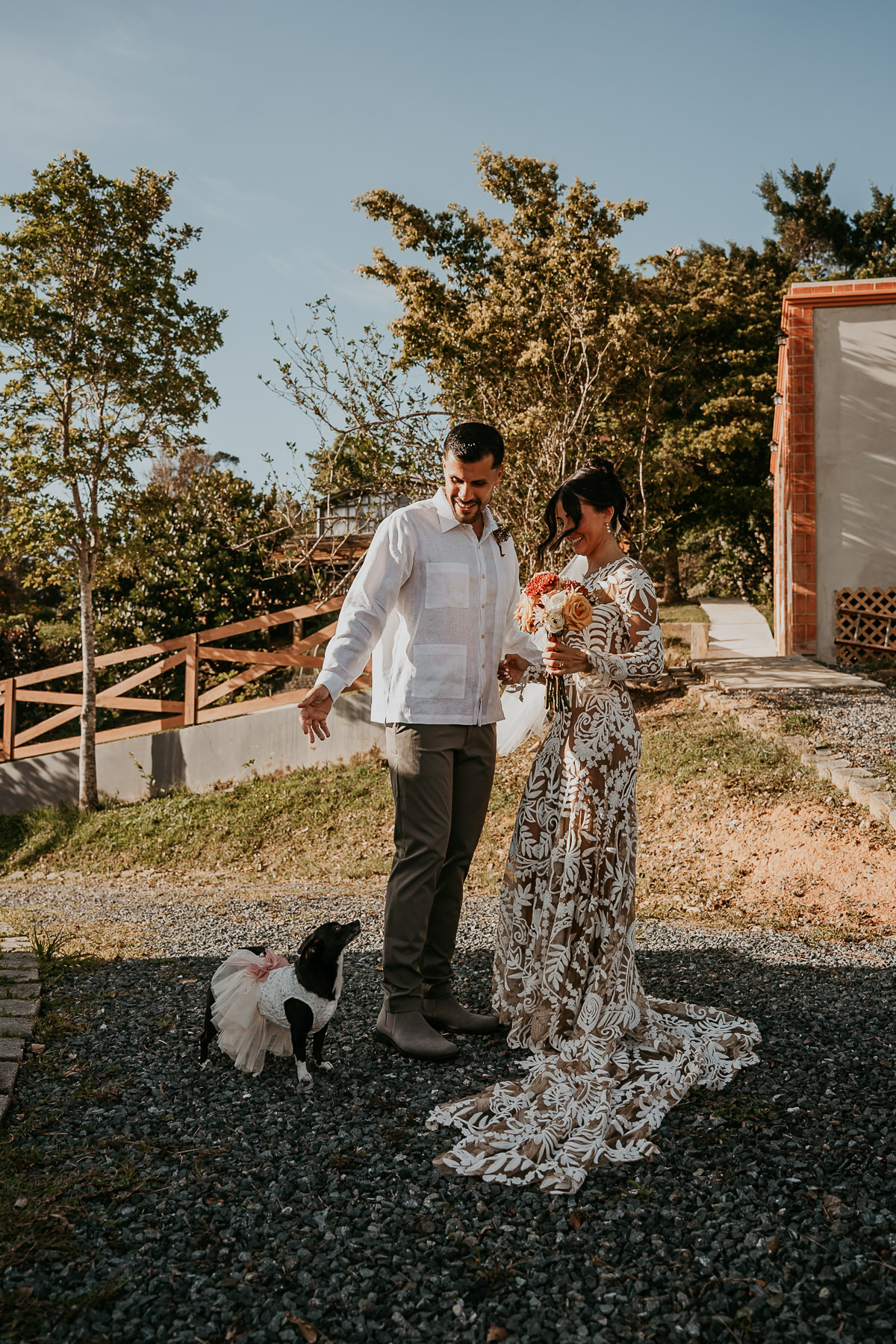 Couple laughing and being playful with their dog during candid mountain wedding in Puerto Rico
