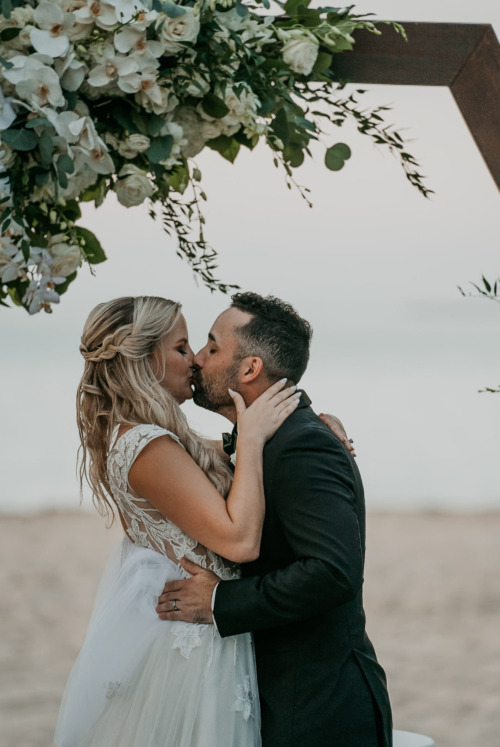 Bride and groom first kiss with the ocean as a backdrop at Courtyard Marriott