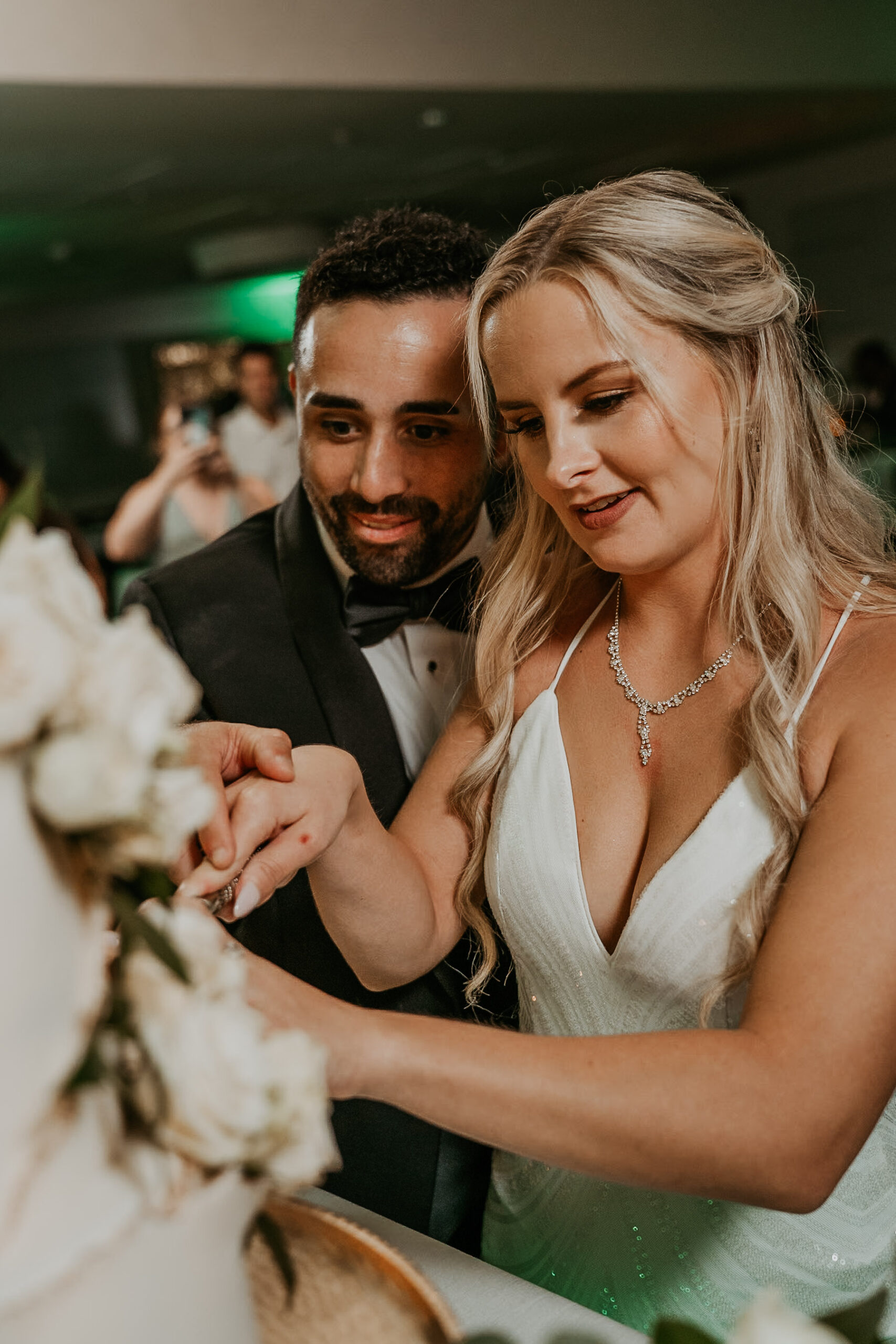 Bride and groom cutting elegant wedding cake during reception at Salon del Mar, Courtyard Marriott