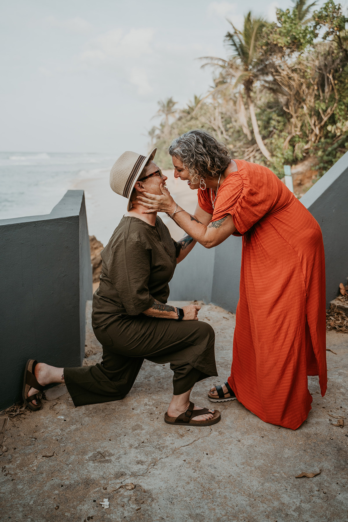 Older lesbian couple beach proposal in Old San Juan Puerto Rico with ocean view, celebrating LGBTQ weddings later in life and diverse love stories