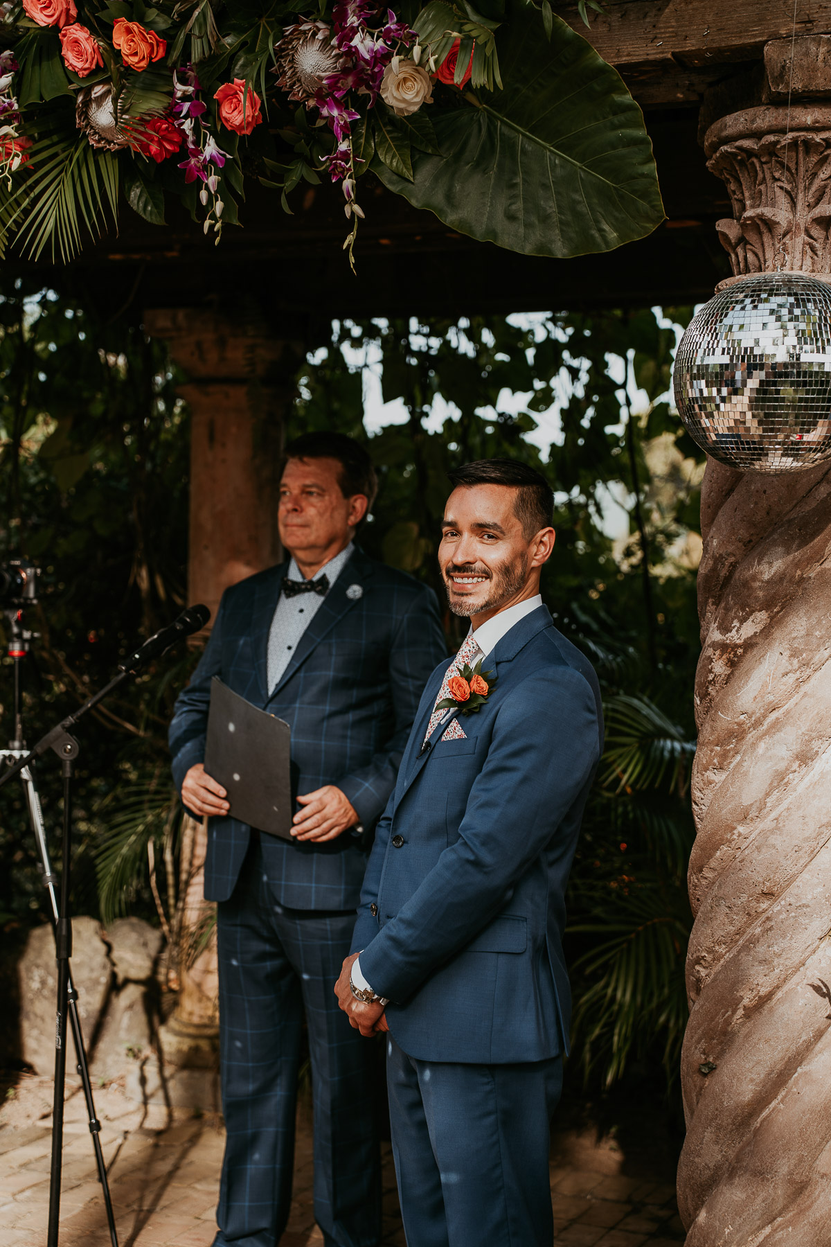 Couple at their LGBTQ+ wedding at Hacienda Siesta Alegre standing under vine-covered pergolas