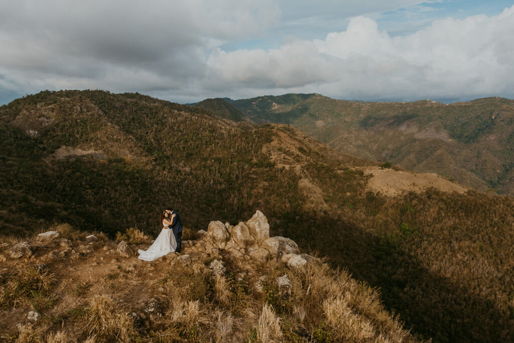 Couple posing before a scenic view of Puerto Rico's mountain range