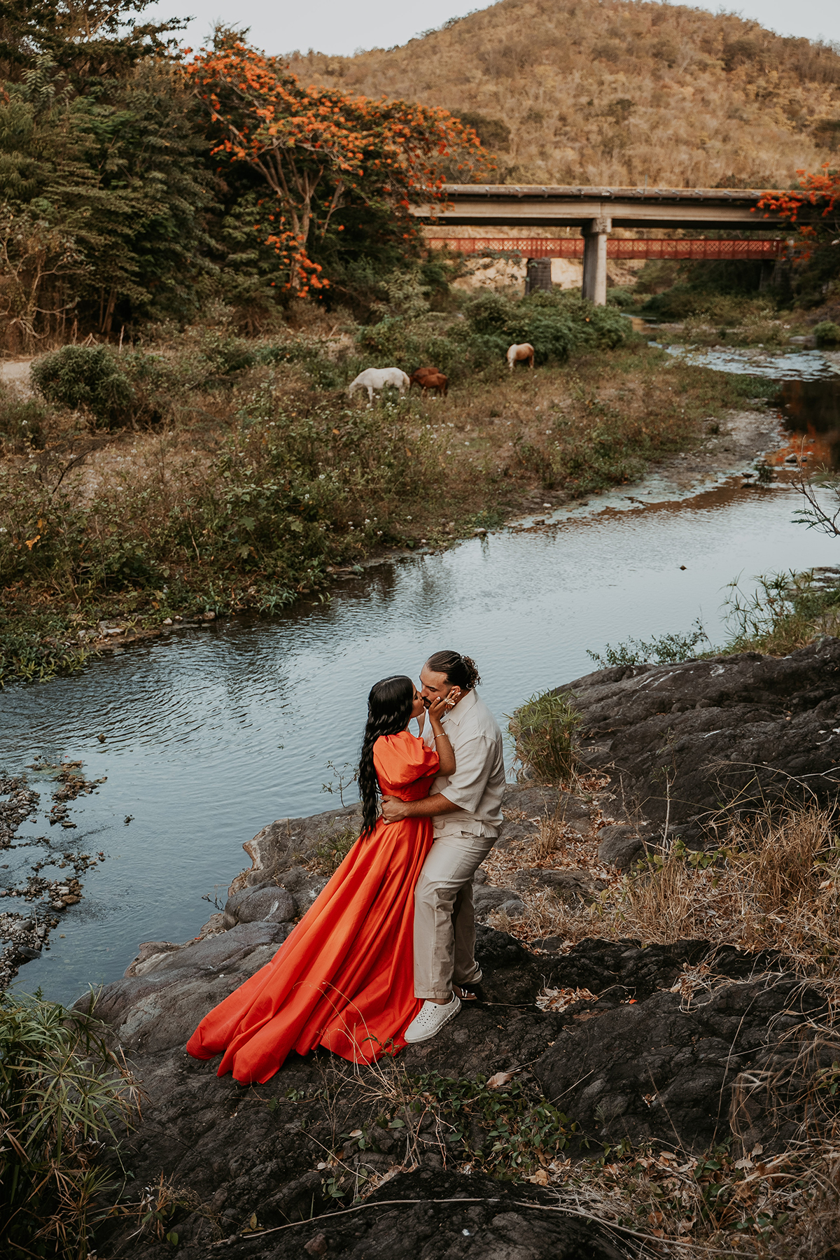 Couple standing near a historic bridge surrounded by lush greenery during a Puerto Rico adventure engagement session