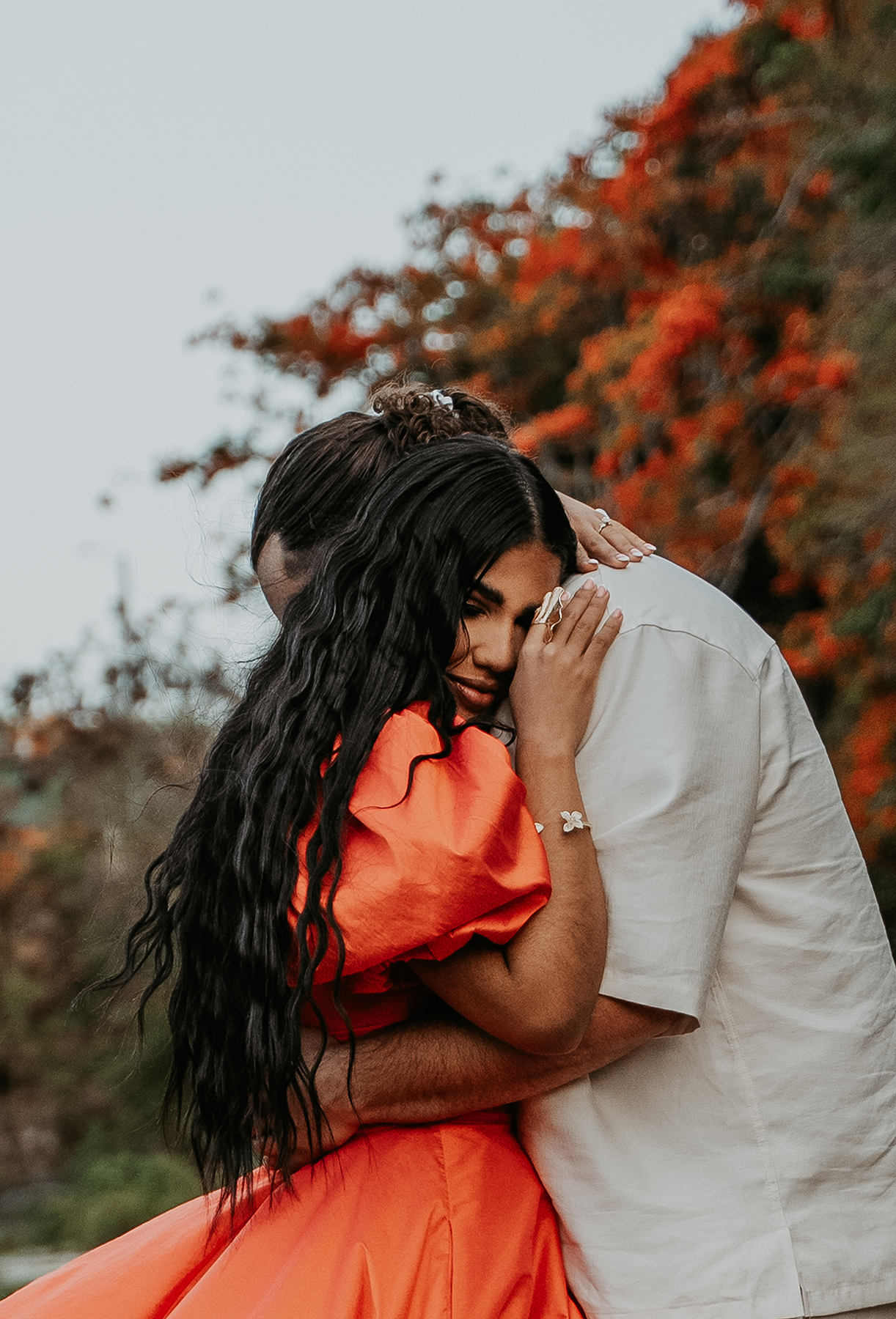 Couple embracing beside tropical vegetation during a candid Puerto Rico adventure engagement session