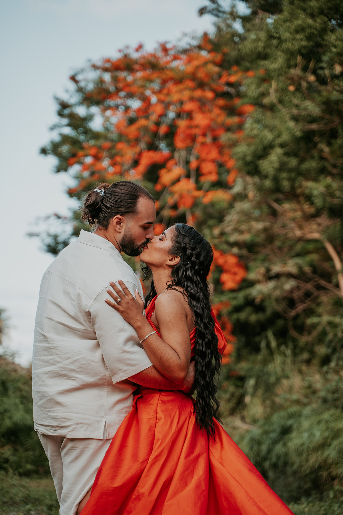 Couple sharing a kiss surrounded by lush greenery during an outdoor Puerto Rico couples photo session