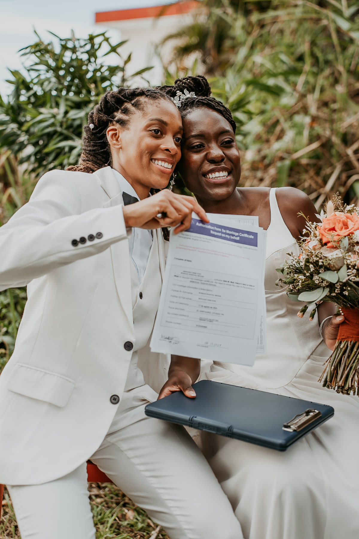 Brides sign marriage certificate during their micro wedding at an Airbnb in Puerto Rico.