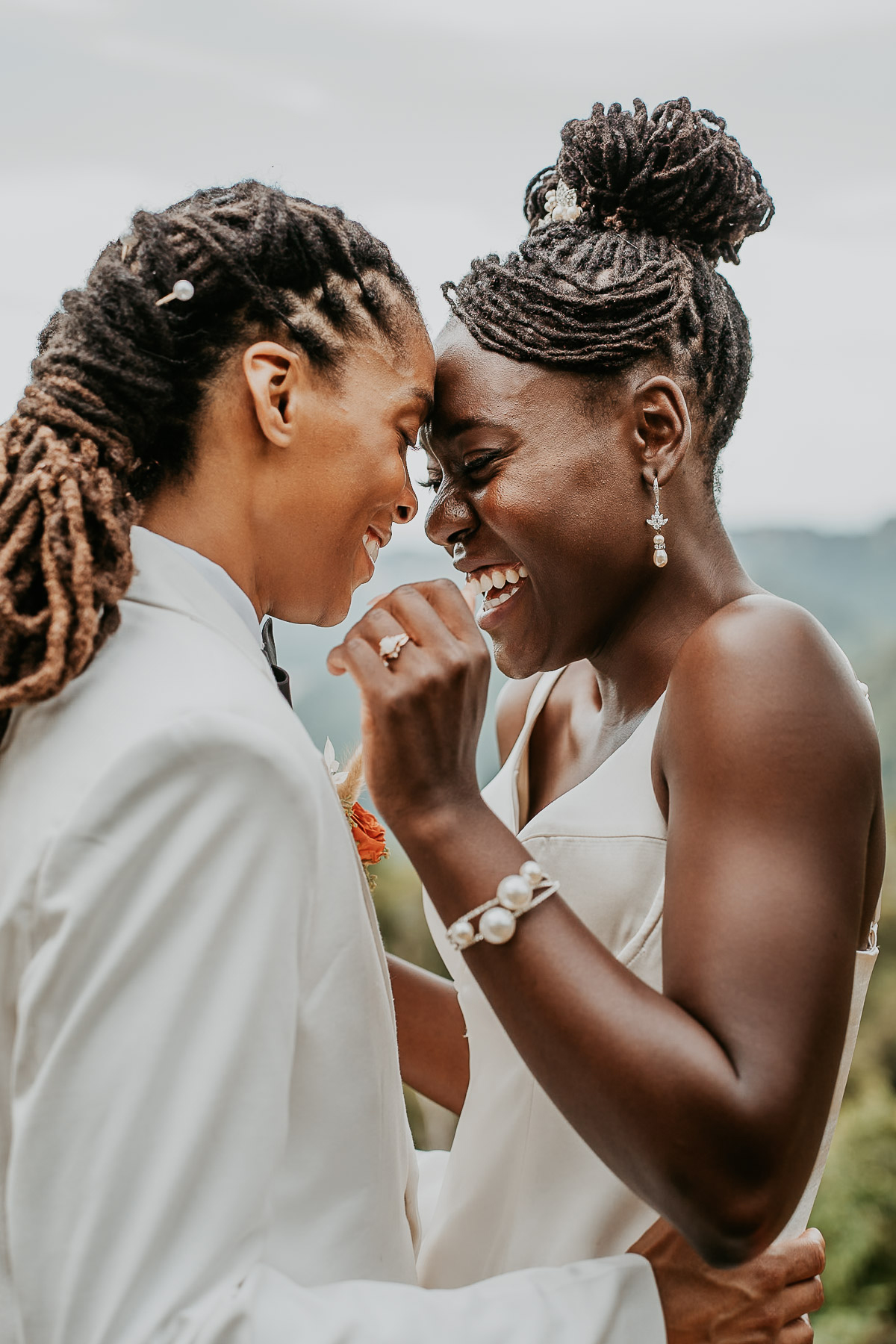 Candid laughter between two brides captured during their micro wedding portraits in Puerto Rico.