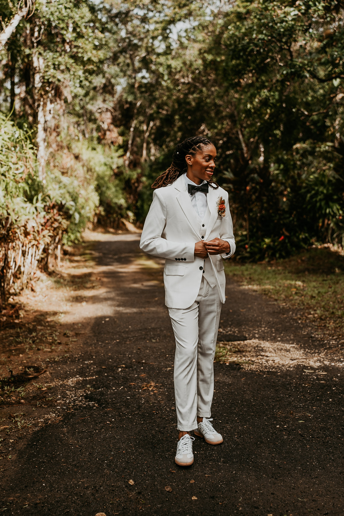 Bride wearing white suit poses for her pictures during her Puerto Rico Micro Wedding.