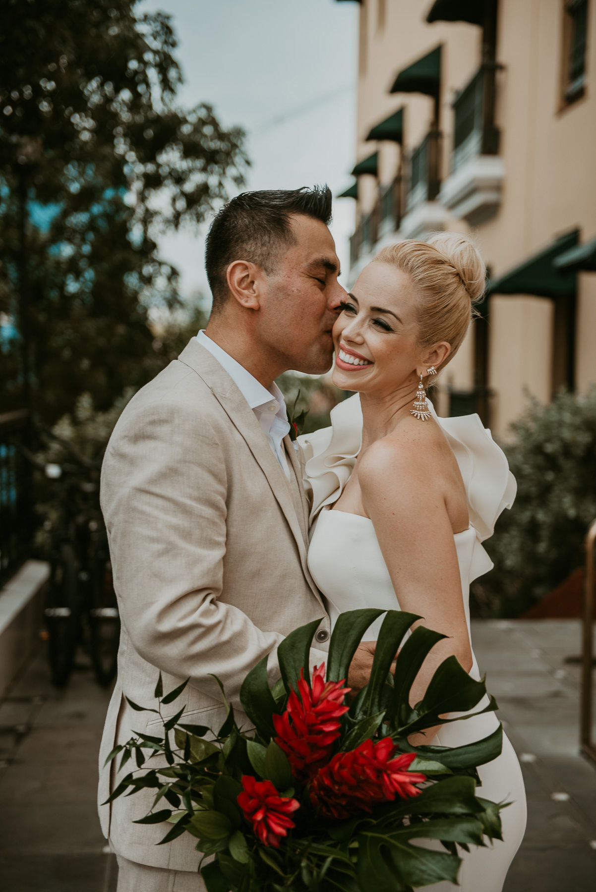 Groom kissing smiling bride in front of Hotel El Convento during their Old San Juan wedding