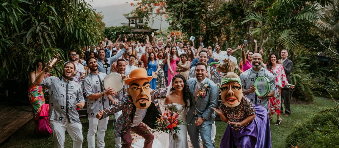 Lively Yuvi Plena musicians leading wedding guests in a vibrant procession with traditional music and dancing.