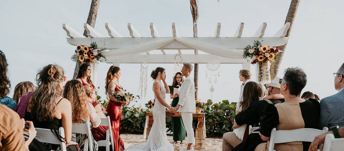 Oceanfront wedding ceremony setup with two brides at the altar.