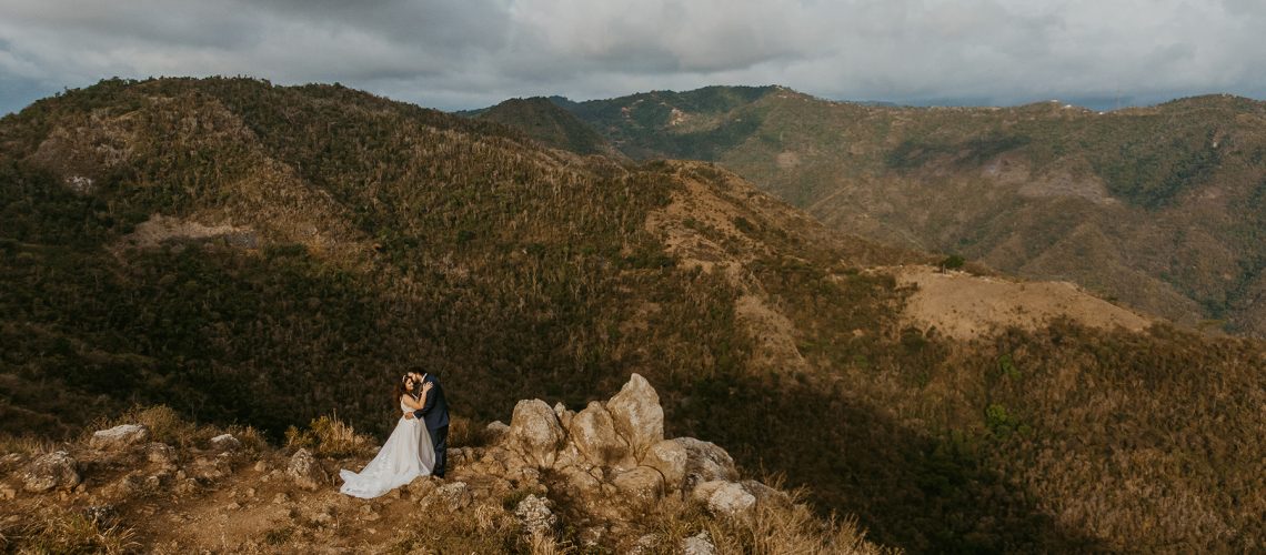 Couple posing before a scenic view of Puerto Rico's mountain range